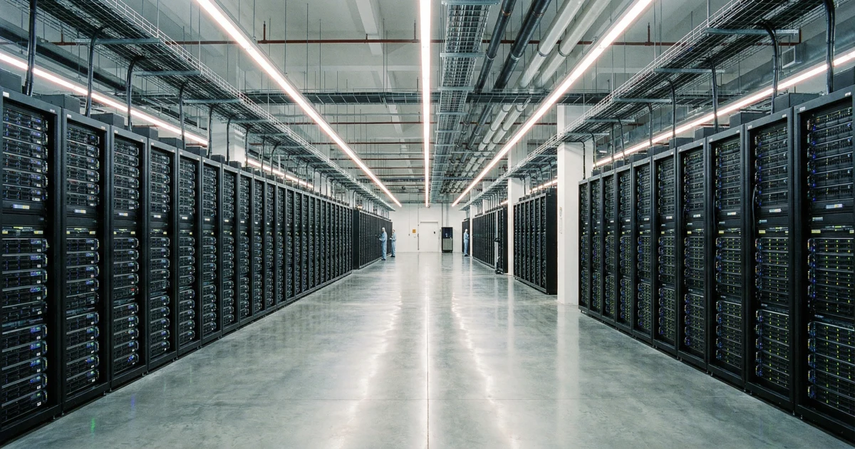 Širokoúhlý záběr na moderní datové centrum s řadami serverových skříní, symbolizující cloud computing.