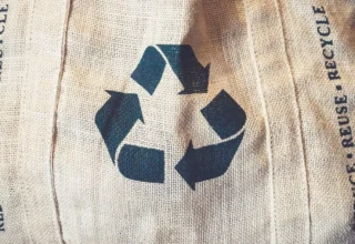 Symbol recyklace na textilii jako připomínka uzavřeného oběhového cyklu