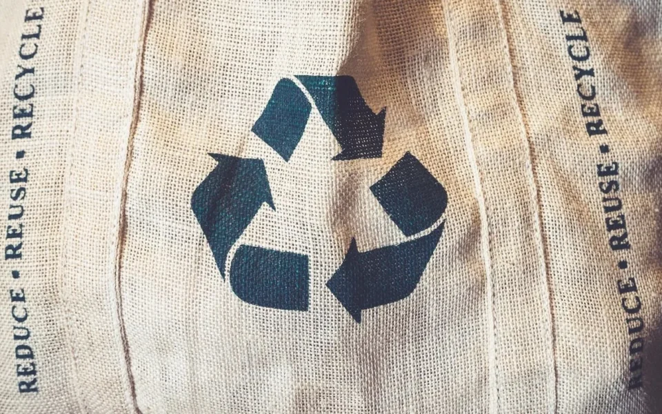 Symbol recyklace na textilii jako připomínka uzavřeného oběhového cyklu